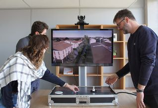 3 personnes en train de faire de la planification urbaine autour d'une table numérique qui modélise la ville en 3D